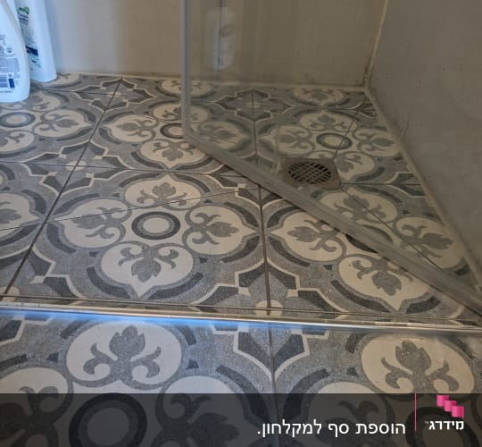 מקלחון עם בקבוקי שמפו על הרצפה